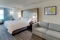 a hotel room with a bed and a couch at Holiday Inn Mobile Airport by IHG in Mobile