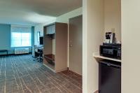 an empty room with a kitchen and a microwave at Holiday Inn Mobile Airport by IHG in Mobile