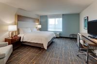 a hotel room with a bed and a desk and a computer at Holiday Inn Mobile Airport by IHG in Mobile