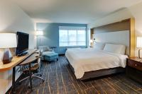 a hotel room with a bed and a desk with a computer at Holiday Inn Mobile Airport by IHG in Mobile