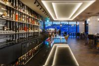 a bar with a long counter with bottles of alcohol at Hotel Adela in Busan