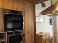 a kitchen with a microwave and a stove at Appartement Les Menuires, 2 pièces, 5 personnes - FR-1-344-855 in Les Menuires