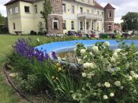 a garden in front of a large house with flowers at Gutshaus Darsikow in Darsikow