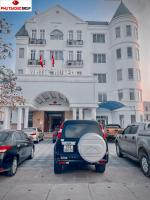 a blue car parked in front of a hotel at White Hotel in Hà Tĩnh