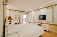 a bedroom with a white bed and a flat screen tv at White Hotel in Hà Tĩnh