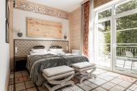 a bedroom with a bed with two chairs and a window at Aries Hotel & SPA Wisła in Wisła