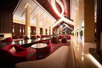 a lobby with red chairs and a table in a building at Beijing Hotel Minsk in Minsk