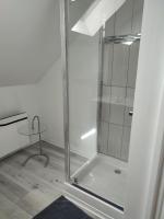 a shower with a glass door in a bathroom at La maison fleurie 2 in Sainte-Geneviève-lès-Gasny