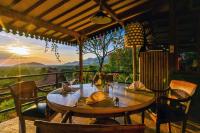 een houten tafel op een balkon met uitzicht op de bergen bij Sumberkima Hill 2 in Pemuteran