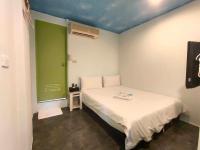 a small room with a bed and a green door at Lantian Baiyun in Hualien City