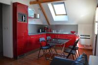a kitchen with red cabinets and a table with chairs at Appartement T2 Le bief des jardins in Bracieux