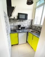 a small kitchen with yellow cabinets and a sink at T2 jacuzzis et piscine au centre ville de Port-Louis in Port-Louis
