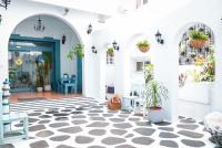 a lobby with white walls and a blue door with potted plants at Bethlehem B&amp;B Kenting in Eluan