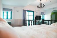 a bedroom with a white bed and a chandelier at Bethlehem B&amp;B Kenting in Eluan