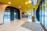 vestíbulo de oficina con techo amarillo y puertas de cristal en Prize by Radisson, Bonn City, en Bonn