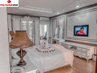a bedroom with a bed with a lamp and a tv at White Hotel in Hà Tĩnh