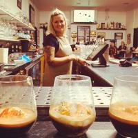 Una mujer parada detrás de un mostrador con tres copas de vino. en Historic Cargo Inn Orange Food & Wine Region, en Cargo