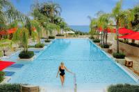 a woman walking into a swimming pool at a resort at Four Seasons Hotel in Limassol
