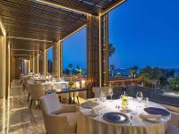 a restaurant with tables and chairs and a view of the ocean at Four Seasons Hotel in Limassol
