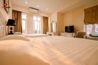 a hotel room with a large bed and a television at White Hotel in Hà Tĩnh