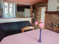 a vase with pink flowers sitting on a table at Entre forêts et prairies in Le Cercueil