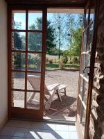 an open door with a picnic table and a bench outside at Entre forêts et prairies in Le Cercueil