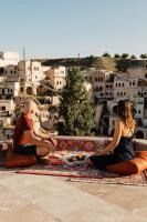 un homme et une femme assis sur un banc pour manger de la nourriture dans l'établissement Narcissos Cave, à Ürgüp