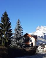 a house on the side of a road with a snow covered mountain at Hotel Val Joly in Saint-Gervais-les-Bains