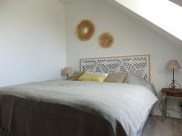a bedroom with a bed and a white wall at Maison Le Tour-du-Parc, 4 pièces, 6 personnes - FR-1-639-51 in Le Tour-du-Parc