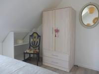 a bedroom with a large white cabinet and a chair at Maison Le Tour-du-Parc, 4 pièces, 6 personnes - FR-1-639-51 in Le Tour-du-Parc