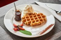 Un plato blanco con gofres, helado y fresas. en Kyriad Lille - Mons en Baroeul, en Mons-en-Baroeul