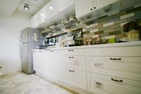 a kitchen with white cabinets and a refrigerator at NK Hostel in Taipei