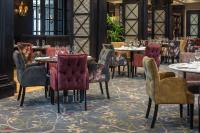 Un restaurante con mesas y sillas con copas de vino. en Oulton Hall Hotel, Spa & Golf Resort, en Leeds