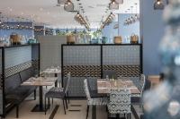 a restaurant with tables and chairs and a bar at Falkensteiner Club Funimation Borik in Zadar