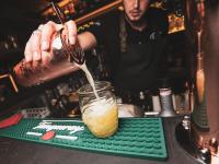 un camarero está vertiendo una bebida en un vaso en Le Vingt-Deux, en Mietesheim