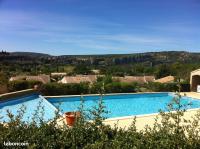 a large swimming pool with a view of a village at LE GECKO GITE in Saint-Martin-dʼArdèche