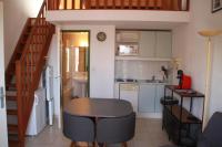 a small kitchen with a table and a staircase at LE GECKO GITE in Saint-Martin-dʼArdèche