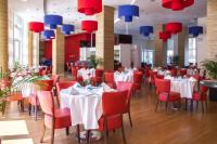 een restaurant met witte tafels en rode stoelen bij Ramada Encore By Wyndham Tangier in Tanger