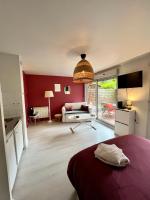 1 dormitorio con pared roja y sala de estar en Cassis - Studio terrasse - Centre Dijon BSB Jouvence, en Dijon