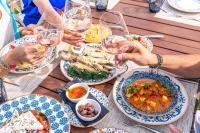 Isla Brown Corinthia Resort & Spa, Curio Collection by Hilton في أغيوي ثيودوروي: مجموعة من الناس يجلسون حول طاولة مع أطباق من الطعام