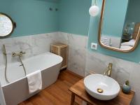 a bathroom with a tub and a sink and a mirror at Péniche Santa Julia au port de Chantilly Insolys in Saint-Leu-dʼEsserent
