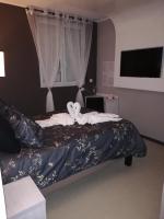 a bedroom with a large bed with a large window at LE PATIO in Millau