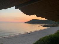 a person sitting on the beach at sunset at U Mo Sognu in Murzo