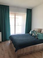 a bedroom with a large bed with green curtains at Ełk Vacation Apartament in Ełk