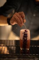 una persona está revolviendo una bebida con una cuchara en De Sol Hotel & Spa, en Fira