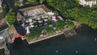 an aerial view of a resort on the water at HERMITAGE Lake Lucerne - Beach Club & Lifestyle Hotel in Luzern