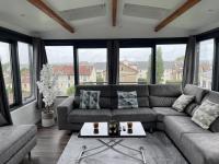 a living room with a couch and a table at Appartement T2, très cosy, vue panoramique in Saint-Cyr-lʼÉcole