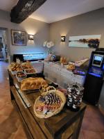a buffet with various types of bread and pastries at Logis Hotel Restaurant la Ferme in Avignon