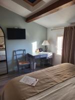 a bedroom with a desk and a bed and a desk at Logis Hotel Restaurant la Ferme in Avignon