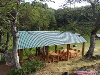 a pavilion with wooden benches and a blue roof at Eko Katun Kolijevka in Berane